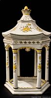 Front view of porcelain pagoda lamp showing roof, columns, floral painting and gold trim