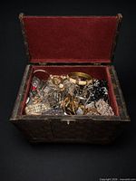 chest open showing large quantity of mixed jewelry