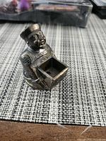 Front view of bronze/brass figurine holding square incense box