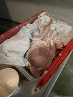 Red tote containing multiple wrapped white ceramic planters