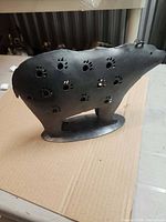 Left side view of bear-shaped metal lantern showing paw-print cutouts