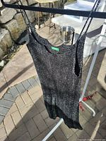 Full front view of black metallic slip dress on hanger