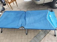 Cot fully opened showing blue fabric and stain