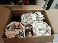 Box containing planters, showing ceramic pots wrapped in packing paper