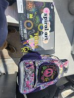 Front of backpack showing peace sign pocket and spiral art kit box