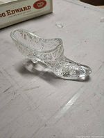 Side view of clear pressed glass shoe figurine showing starburst pattern