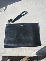 Front view of black Coach saffiano wristlet