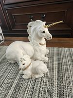 Adult and foal unicorn figurines side by side on table