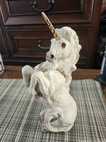 Front three-quarter view of full unicorn figurine showing pose, horn, chain with Swarovski stones