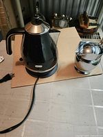Kettle with base and creamer pitcher on tabletop