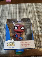 Front view of Spider-Man ornament inside damaged box