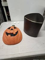 Front view of pumpkin decoration and wastebasket together