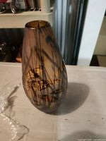 Front view of amber and black hand-blown glass vase