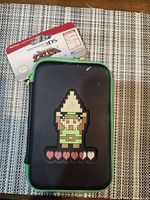 Front of pouch showing 8-bit Link graphic and attached retail tag