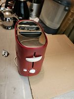 Front view of red hot dog toaster showing white lever and dial