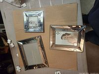 Three mirrored silver frames on tabletop