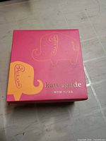 Front of pink Kate Spade box with elephant graphics