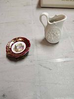 Miniature Limoges plate on stand and white creamer side by side