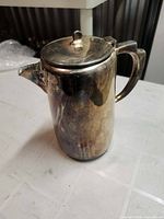 Side view of silver-plated coffee pot with tarnish