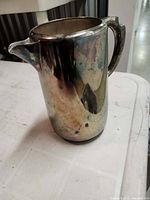 Front view of silver-plated creamer showing tarnish and handle