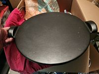 Top view of black ceramic pizza stone with handles