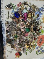 Top view of entire mixed jewelry pile on floral tray