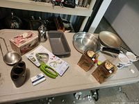 All items laid out on table including pans, loaf pan, mugs, utensils, storage containers and boxed gadgets