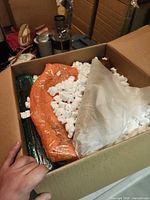 Box containing wrapped items with packing peanuts