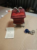 Jewelry box closed with artist card and two glass spheres visible