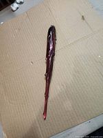 Full view of red/burgundy glass icicle ornament