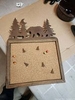 Front view of cork bulletin board showing metal bear silhouette and push pins
