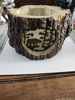 Front view showing bear and trees silhouette and log texture