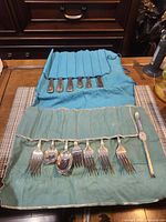 Flatware in two cloth rolls showing contents