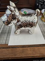 Left side view of silver ceramic terrier figurine