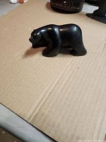 Left side view of small black resin bear figurine