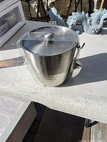 Full view of stainless stockpot with lid and tongs
