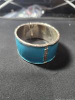 wide turquoise enamel metal cuff in closed position