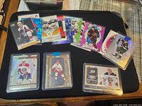 Overview of all 11 sleeved/top-loaded cards on black mat