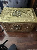 Top and front view showing embossed brass-tone metal chest