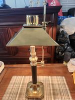 Full view of brass Chapman bouillotte lamp with shade and pull rod