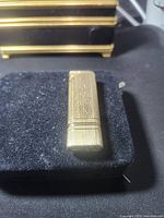 Front view of brushed gold-tone Colibri lighter