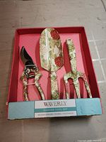 Front view of boxed Waverly floral garden tool set showing pruning shears, trowel, hand cultivator
