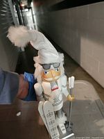 Front view of white and silver ski nutcracker showing accessories