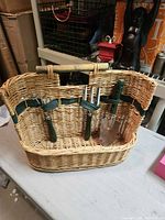 Front view of wicker gardening tote with tools attached