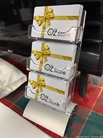 Display stand holding The OZ Store gift cards with yellow ribbon design