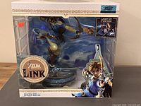 Front of sealed retail box showing Link statue, branding, light-up function icon