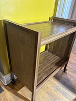three-quarter view of cart showing walnut finish, faux cane side and casters