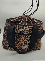 Front view showing leopard pattern, drawstring closure and handles