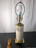 Full view of Lenox Quoizel porcelain lamp with harp and CFL bulb