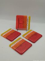 Four fused glass coasters, one displayed upright to show full pattern